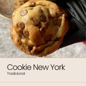 Cookie New York tradicional segurado com luva preta, cookie grande e recheado com gotas de chocolate